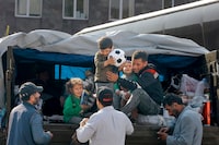 Ethnic Armenian family from Nagorno-Karabakh are helped to leave a truck with their belongings after arriving to Armenia's Goris in Syunik region, Armenia, on Saturday, Sept. 30, 2023. Armenian officials say that by Friday evening over 97,700 people had left Nagorno-Karabakh. The region's population was around 120,000 before the exodus began. (AP Photo/Vasily Krestyaninov)