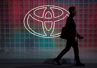 FILE PHOTO: A man walks past a Toyota logo at the Tokyo Motor Show, in Tokyo, Japan October 24, 2019. REUTERS/Edgar Su/File Photo