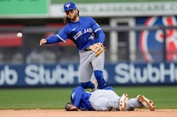 Toronto Blue Jays' shortstop Bo Bichette, top, throws over Isiah Kiner-Falefa for an out at first base during the seventh inning of the baseball game against the New York Yankees at Yankee Stadium Friday, April 5, 2024, in New York. (AP Photo/Seth Wenig)