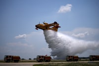 FILE - A Canadair water-bomber aircraft drops water during an exercise as French President Emmanuel Macron visits the Nimes-Garons firefighters air base, Friday, June 2, 2023 near Nimes, southern France. Production of a workhorse fire-fighting plane that is eagerly awaited in Europe to combat worsening mega-blazes fueled by climate change is slipping "a little bit" behind schedule and the first will now not be delivered before the fire season of 2027 — the year after some governments hoped, manufacturer De Havilland Canada said. (AP Photo/Daniel Cole, Pool, File)