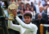 Tennis - Wimbledon - All England Lawn Tennis and Croquet Club, London, Britain - July 16, 2023 Spain's Carlos Alcaraz celebrates with the trophy after winning his final match against Serbia's Novak Djokovic REUTERS/Toby Melville
