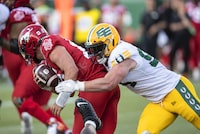 Calgary Stampeders quarterback Tommy Stevens (15) is sacked by Edmonton Elks Jake Ceresna (94) during first half CFL pre season action in Edmonton, Friday, June 3, 2022. THE CANADIAN PRESS/Jason Franson