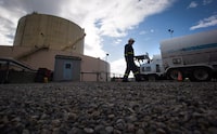 A FortisBC employee walks past a storage tank and delivery trucks at the existing FortisBC Tilbury LNG facility before the groundbreaking for an expansion project in Delta, B.C., on Tuesday, Oct. 21, 2014. An environmental group is suing British Columbia natural gas utility FortisBC, accusing it of "greenwashing" its product through advertising, making the company seem more environmentally friendly than it is. THE CANADIAN PRESS/Darryl Dyck