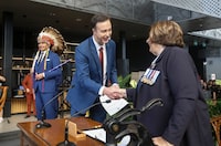 The Manitoba government is planning to do away with paper health cards and switch to more durable plastic and digital ones. Manitoba Premier Wab Kinew looks on as Finance Minister Adrien Sala is sworn-in by Lt. Gov. Anita Neville in Winnipeg on Oct. 18, 2023. THE CANADIAN PRESS/John Woods
