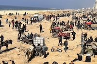 Palestinians wait for humanitarian aid on a beachfront in Gaza City, Gaza Strip, Sunday, Feb. 25, 2024. (AP Photo/Mahmoud Essa)