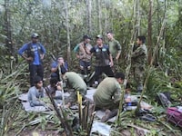 In this photo released by Colombia's Armed Forces Press Office, soldiers and Indigenous men tend to the four Indigenous brothers who were missing after a deadly plane crash, in the Solano jungle, Caqueta state, Colombia, Friday, June 9, 2023. Colombian President Gustavo Petro said Friday that authorities found alive the four children who survived a small plane crash 40 days ago and had been the subject of an intense search in the Amazon jungle that held Colombians on edge. (Colombia's Armed Force Press Office via AP)