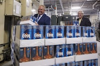 Ontario Premier Doug Ford, left, and Ontario Finance Minister Vic Fedeli, stack cases of beer during a photo opportunity at a brewery in Etobicoke, Ont. on Monday, Aug. 27, 2018. The Progressive Conservative government has tabled legislation that would terminate a contract with The Beer Store. THE CANADIAN PRESS/Cole Burston