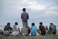 Ethnic Rohingya men chat on the beach where they landed on Dec. 10 in Pidie, Aceh province, Indonesia, Saturday, Dec. 16, 2023. The Associated Press has interviewed five Rohingya refugees who were rescued from the first boat and arrived in Indonesia, revealing a few clues about the fate of the other boat, now missing for weeks. Until now, almost nothing was known about the vanished vessel, beyond that it left Bangladesh in November. (AP Photo/Reza Saifullah)
