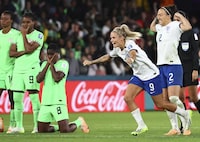 England's Rachel Daly, and England's Lucy Bronze celebrate after winning the Women's World Cup round of 16 soccer match against Nigeria in Brisbane, Australia, Monday, Aug. 7, 2023. From left are Nigeria's Blessing Demehin, Nigeria's Desire Oparanozie, and Nigeria's Asisat Oshoala, reacting after losing. (AP Photo/Tertius Pickard)