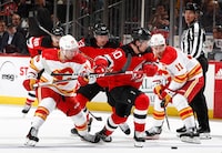 NEWARK, NEW JERSEY - FEBRUARY 08: Alexander Holtz #10 of the New Jersey Devils controls the puck as Andrew Mangiapane #88 and Mikael Backlund #11 of the Calgary Flames defend during the second period at Prudential Center on February 08, 2024 in Newark, New Jersey. (Photo by Sarah Stier/Getty Images)
