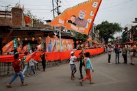 Boys wave a Bharatiya Janata Party (BJP) flag before the start of India's Prime Minister Narendra Modi's election campaign rally in Kanpur, India, May 4, 2024. REUTERS/Francis Mascarenhas