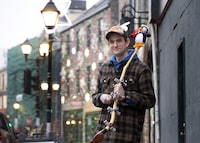 Dave Rowe, owner of O'Brien's Music Store poses with an ugly stick: a traditional Newfoundland and Labrador percussion musical instrument, outside his shop on Water Street, St. John's, Monday, Dec. 4, 2023. THE CANADIAN PRESS/Paul Daly