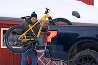 Jonah Clark, owner of Icycle Sports, loads a bike into the back of his Ford F-150 Lightning in Whitehorse on January 28, 2024. Clark has two other electric vehicles, a Ford cargo van for business use and a Tesla Model Y long range crossover SUV for personal use.