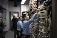 EV battery researcher Chongyin Yang, right, fits a battery cell amongst the charge/discharge units while working with colleagues Jeff Dahn, left, and Michael Metzger in a battery testing lab at Dalhousie University in Halifax on Tuesday, January 30, 2024.

Darren Calabrese/The Globe and Mail�
