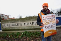 A health worker protests at a picket line outside of St George's Hospital, as junior doctors strike over pay and conditions, in London, Britain, December 21, 2023. REUTERS/Isabel Infantes