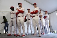FILE - Philadelphia Phillies players wait to have their photo taken during a baseball spring training photo day Thursday, Feb. 22, 2024, in Clearwater, Fla. Baseball players’ association head Tony Clark is hopeful 2024 uniforms will soon be altered following complaints by his members. The uniforms designed by Nike and manufactured by Fanatics have been criticized by players for pants that are somewhat see through and for lettering, sleeve emblems and numbering that are less bulky and apparently smaller.(AP Photo/Charlie Neibergall, File)