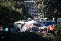 Vancouver officials say the dozens of homeless people staying in the city's only legal encampment have to temporarily move out because the space has become unsafe and unhygienic. A person sits in a tent at a homeless encampment at Crab Park in Vancouver, on Sunday, Aug. 14, 2022. THE CANADIAN PRESS/Darryl Dyck