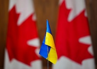 A Ukrainian flag is pictured in front of Canadian flags in Ottawa on Friday, April 1, 2022. A free new summer camp aims to help Ukrainian refugee children and their families settle in Montreal. THE CANADIAN PRESS/Sean Kilpatrick