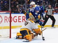 Nashville Predators goalie Juuse Saros, front, stops Vancouver Canucks' Brock Boeser, middle, as he is checked by Nashville Predators' Alexandre Carrier during the third period in Game 5 of an NHL hockey Stanley Cup first-round playoff series, in Vancouver, on Tuesday, April 30, 2024. THE CANADIAN PRESS/Darryl Dyck