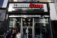 FILE PHOTO: People walk by a GameStop in Manhattan, New York, U.S., December 7, 2021. REUTERS/Andrew Kelly/File Photo