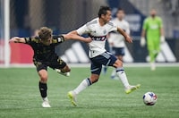 Los Angeles FC's Nathan Ordaz, left, grabs the jersey of Vancouver Whitecaps' Andres Cubas as they vie for the ball during the second half in game 2 of a first round MLS playoff soccer match, in Vancouver, on Sunday, November 5, 2023.The Whitecaps will renew acquaintances with Los Angeles FC, which ended their playoff run last season, in the Leagues Cup this season. THE CANADIAN PRESS/Darryl Dyck