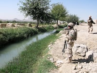 Canadian soldiers stand beside a canal near the village of Charbagh on the outskirts of Kandahar in this Oct. 3, 2009 photo.&nbsp;Canadians who served in Afghanistan say many of their Afghan family members don't qualify to come to Canada, even though their lives are at risk.&nbsp;THE CANADIAN PRESS/Bill Graveland