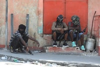 Gang members sit together after former police officer Jimmy "Barbecue" Cherizier, and leader of an alliance of armed groups, addressed the media, in Port-au-Prince, Haiti, March 11, 2024. REUTERS/Ralph Tedy Erol