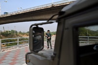 Thai military personnel keeps guard along the Moei river on the Thai side, next to the 2nd Thai-Myanmar Friendship Bridge, in Thailand's Mae Sot district on April 12, 2024. Myanmar troops have withdrawn from their positions in a trade hub near the Thai border, a spokesman for the junta said, confirming reports from an ethnic armed group that has been battling the military for days. (Photo by Manan VATSYAYANA / AFP) (Photo by MANAN VATSYAYANA/AFP via Getty Images)