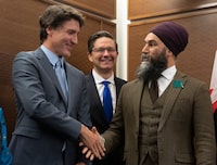 Prime Minister Justin Trudeau shakes hands with New Democratic Party leader Jagmeet Singh as Conservative leader Pierre Poilievre looks on at a Tamil heritage month reception, Monday, January 30, 2023 in Ottawa.  THE CANADIAN PRESS/Adrian Wyld
