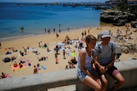 FILE PHOTO: Tourists take a photo near a beach in Cascais, Portugal, June 6, 2022. REUTERS/Pedro Nunes/File Photo