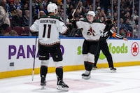 Arizona Coyotes' Dylan Guenther (11) celebrates with Logan Cooley (92) after scoring against the Vancouver Canucks during NHL overtime action in Vancouver, on Wednesday, April 10, 2024. THE CANADIAN PRESS/Ethan Cairns 