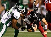 Saskatchewan Roughriders defensive lineman Christian Albright (97) tears the jersey of Ottawa Redblacks quarterback Dustin Crum (18) as he sacks him, during first half CFL football action in Ottawa on Friday, Sept. 22, 2023. THE CANADIAN PRESS/Justin Tang