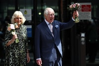 Britain's King Charles III and Britain's Queen Camilla, holding bunches of flowers, wave to crowds after to visit to the University College Hospital Macmillan Cancer Centre in London on April 30, 2024. Charles is making his first official public appearance since being diagnosed with cancer, after doctors said they were "very encouraged" by the progress of his treatment. (Photo by HENRY NICHOLLS / AFP) (Photo by HENRY NICHOLLS/AFP via Getty Images)