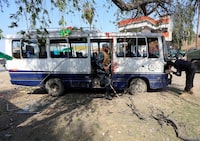 Afghan policemen inspect a damaged minibus after a blast in Jalalabad, Afghanistan March 19, 2018.REUTERS/Parwiz