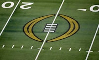 FILE - The College Football Playoff logo is shown on the field at AT&T Stadium before the Rose Bowl NCAA college football game between Notre Dame and Alabama in Arlington, Texas, Jan. 1, 2021. College Football Playoff managers meet outside Chicago, facing the possibility of a conference-realignment induced tweak to how the field is set when the postseason system expands to 12 teams next year. (AP Photo/Roger Steinman, File)