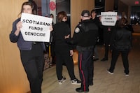 Protesters are escorted out of the Four Seasons Hotel by the police after interrupting the Scotiabank Giller Prize ceremony in Toronto, on Monday, November 13, 2023.&nbsp;Corporations are under increasing scrutiny for where they stand on the Israel-Hamas conflict as protesters push for peace. THE CANADIAN PRESS/Chris Young