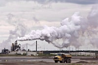 New research suggests Alberta's oilsands are releasing potentially hazardous compounds into the atmosphere at rates dozens of times higher than official estimates. A dump truck works near the Syncrude oilsands extraction facility near the city of Fort McMurray, Alta., on June 1, 2014. THE CANADIAN PRESS/Jason Franson