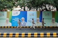 FILE PHOTO: Police officers walk past posters with the picture of India's Prime Minister Narendra Modi on the first day of the G20 summit in New Delhi, India, September 9, 2023. REUTERS/Francis Mascarenhas/File Photo