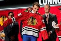 Chicago Blackhawks first round draft pick Connor Bedard puts on his jersey after being picked by the team during the first round of the NHL hockey draft, Wednesday, June 28, 2023, in Nashville, Tenn. (AP Photo/George Walker IV)