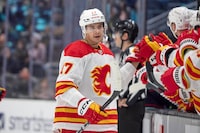 Calgary Flames center Yegor Sharangovich (17) is congratulated for his goal against the Seattle Kraken during the third period of an NHL hockey game, Saturday, Nov. 4, 2023, in Seattle. (AP Photo/John Froschauer)