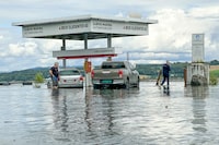 Cars at a petrol station hit by floodwater, Friday Aug. 11. 2023. More evacuations were being considered Friday in southeastern Norway, where the level of water in swollen rivers and lakes continued to grow after days of torrential rain. (Heiko Junge/NTB via AP)
