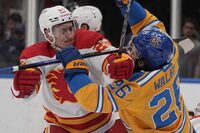Calgary Flames' Michael Stone, left, collides with St. Louis Blues' Nathan Walker during the second period of an NHL hockey game Tuesday, Jan. 10, 2023, in St. Louis. Canadian hockey player Michael Stone has retired and joined the front office staff of the Calgary Flames.THE CANADIAN PRESS/AP, Jeff Roberson