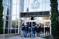Italian carabinieri and anti-Ndrangheta police officers arrive at the Interpol headquarters in Lyon, central France, Thursday, Feb.2, 2023. An Interpol statement said French police, with help from Italian colleagues, arrested Edgardo Greco in Saint-Etienne, central France. He was wanted for two murders in 2006 and accused of attempted murder in another case. Italian authorities said the two people killed in 2006 were brothers who were beaten to death with a metal bar in a fish shop in Calabria. (Interpol via AP)