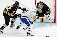 Boston Bruins' Jeremy Swayman (1) blocks a shot by Toronto Maple Leafs' John Tavares (91) as Bruins' Andrew Peeke (52) defends during the second period in Game 1 of an NHL hockey Stanley Cup first-round playoff series Saturday, April 20, 2024, in Boston. (AP Photo/Michael Dwyer)