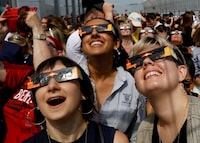 FILE PHOTO: People watch the solar eclipse from the observation deck of The Empire State Building in New York City, U.S., August 21, 2017.  Location coordinates for this image are 40?44'54" N 73?59'8" W.   REUTERS/Brendan McDermid/File Photo
