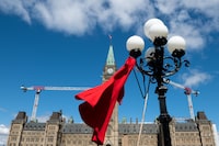 Canada and Manitoba are partnering to launch an Indigenous-led alert system that would inform the public when an Indigenous woman or girl goes missing, they announced today in Winnipeg. A red dress is hangs on a light fixture on National Day of Awareness for the prevention of violence against Indigenous women, also known as the Red Dress Day in Ottawa, Friday, May 5, 2023. THE CANADIAN PRESS/Spencer Colby
