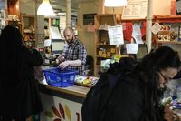 Store manager Zachary Weingarten helps members cash out at the Karma Co-op Food Store in Toronto, Friday, March 15, 2024. The co-op focuses on local, organic and ethically produced foods, with many products available in bulk for zero-waste shoppers. THE CANADIAN PRESS/Chris Young