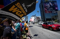 Picketers carry signs outside Netflix during a Writers Guild rally on Thursday, July 13, 2023, in Los Angeles. (AP Photo/Mark J. Terrill)