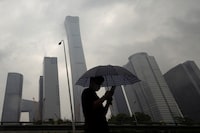 A man walks in the Central Business District on a rainy day, in Beijing, China, July 12.
