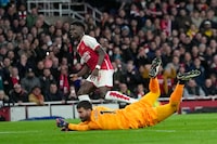 Arsenal's Bukayo Saka, top, scores his side's first goal during the English Premier League soccer match between Arsenal and Liverpool at Emirates Stadium in London,, Sunday, Feb. 4, 2024. (AP Photo/Kin Cheung)